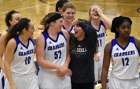 Allie Dittmer's (52) teammates surround her after she scored her 1,000th career point in Hillsdale's 103-50 win over Lake Erie. Photo by Carly Gouge