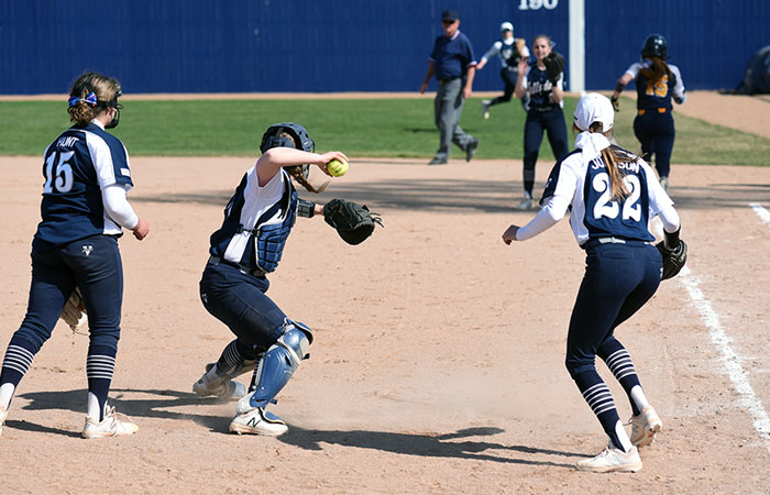 (Lr): Erin Hunt, Madison Stoner and Emma Johnson cover a bunt during the first game of Thursday's doubleheader. Photo by Todd Lancaster