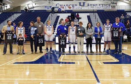The seniors on the Charger women's basketball team - Michele Boykin (21), Jessica De Gree (33), Maddy Reed (34) and Allie Dittmer (52) pose with their families on Senior Day. Photo by Todd Lancaster